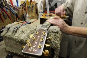 Barrett Coughlan, Luthier repairing guitar strings in Portland, Oregon shop